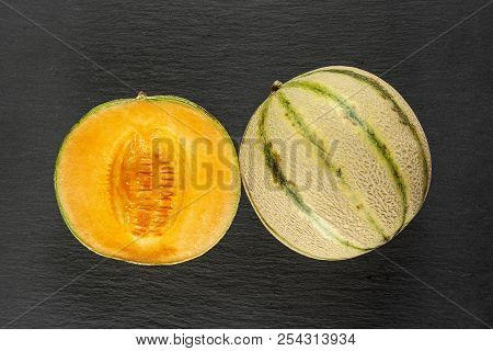 Group Of One Whole One Half Of Fresh Melon Cantaloupe Variety Flatlay On Grey Stone