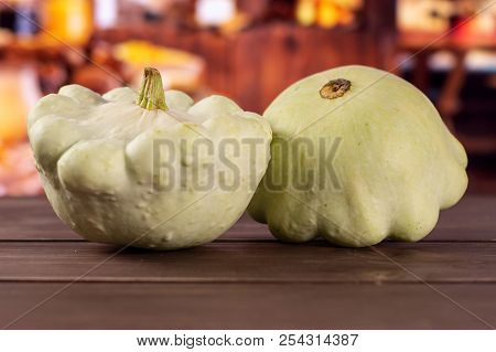 Group Of Two Whole Summer White Pattypan Squash With Rustic Wood Kitchen In Background