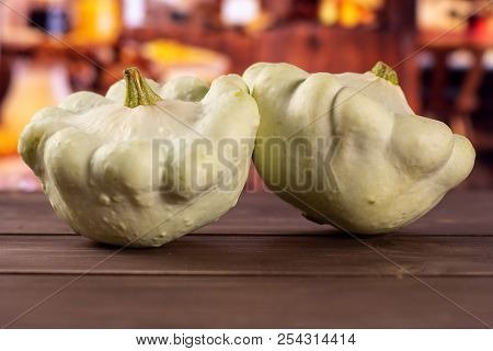 Group Of Two Whole Summer White Pattypan Squash With Rustic Wood Kitchen In Background