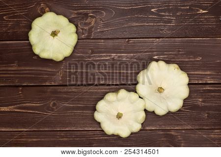 Group Of Three Whole Summer White Pattypan Squash Flatlay On Brown Wood