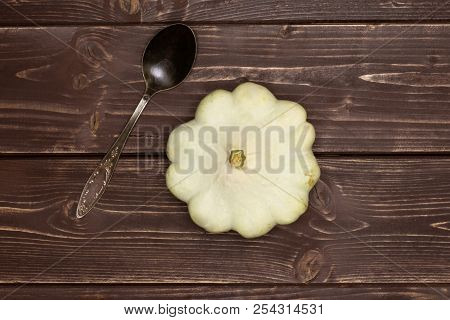 One Whole Summer White Pattypan Squash With A Spoon Flatlay On Brown Wood