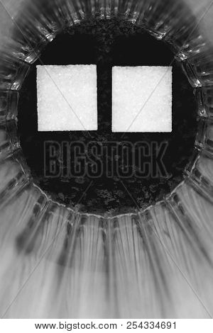 Two Pieces Of Sugar In A Glass With An Insoluble Coffee. Black & White.