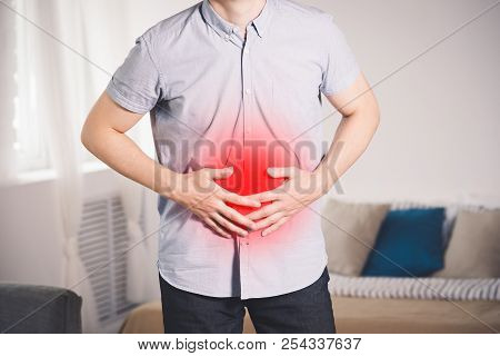 Stomach Ache, Man With Abdominal Pain Suffering At Home, Painful Area Highlighted In Red