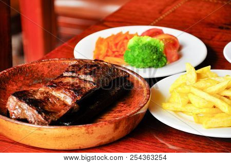 Steak On A Stone, With Vegetables And French Fries