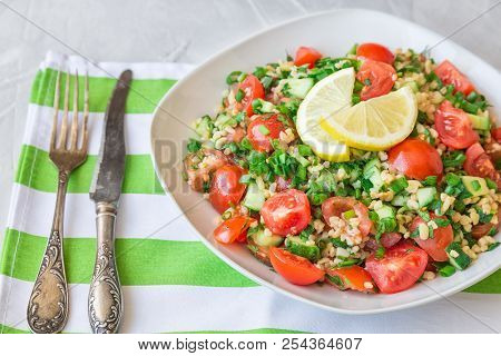 Tabbouleh (tabouli) Salad On A Dish On Light Gray Concrete Background. Healthy Vegetarian Food. Leba