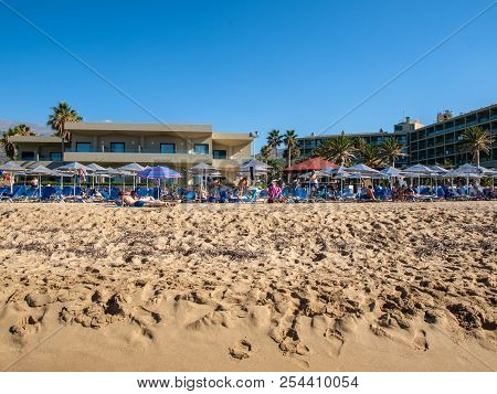 Malia, Crete, Greece - July 1, 2018: People Are Resting On A Sunny Day At The Beach In Malia, Crete,