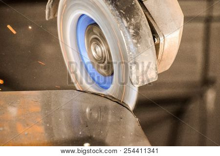 Heavy Industry Worker Cutting Steel With Angle Grinder At Car Service