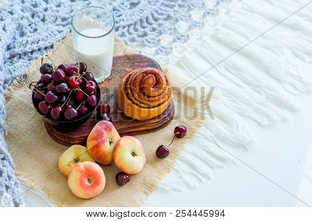Homemade Cinnamon Buns In Glaze On A Dark Plate With Berries