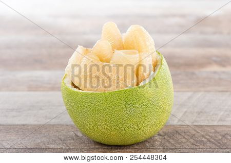 Fresh And Peeled Pomelo(shaddock), Grapefruit With Slices On Wooden Table Background