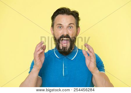 Overwhelmed With Emotions. Handsome Shouting Mature Man Screaming Standing Against Yellow Background