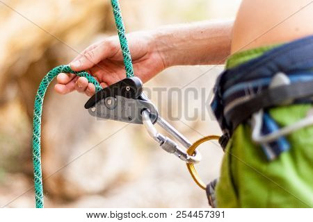 A Closeup Image Of A Climber Belaying His Partner.