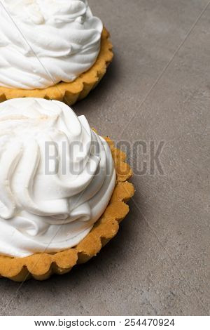 Delicious Merengue Dessert. Lemon Tartlet Tart With With Meringue On Grey Stone Concrete Table Backg