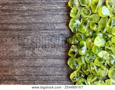 Olivine Gemstone Also Called Peridot On Old Wooden Background.selective Focus