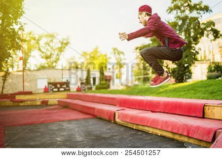 Young Man Freerun In The Summer City Public Park Running, Jumping And Flying, Parkour Concept