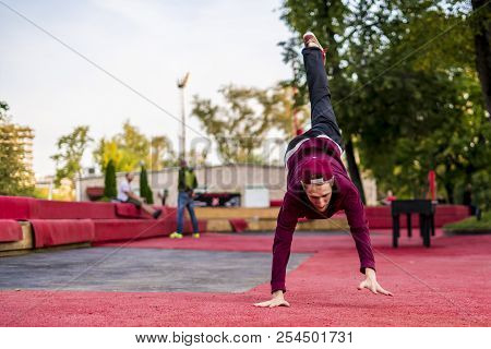 Young Man In Casual. Freerun In Urban City Doing Somersault Roll While Running