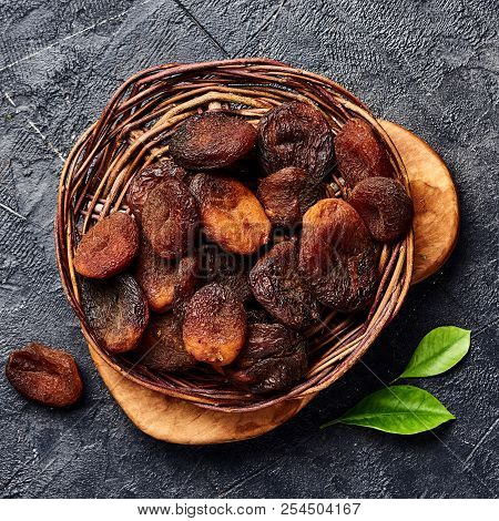 Brown Sun Dried Apricots On Black Table. Top View.