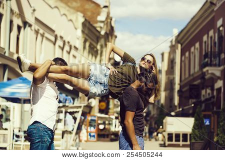 Two Handsome Men Holding Pretty Girl Or Beautiful Woman In Sunglasses And Jean Shorts On Shoulders O