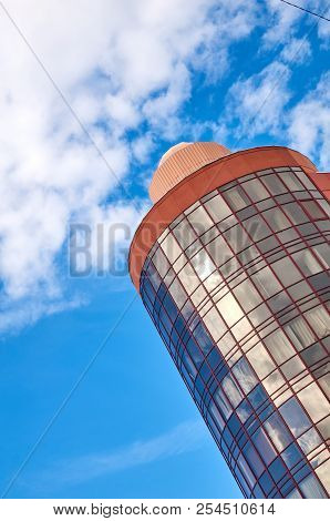 Modern Skyscraper With A Unique Round Shape, Cloudy Sky Background, Copy Space