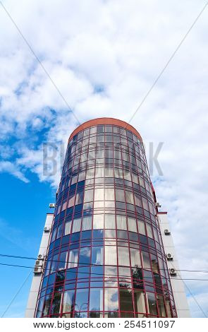 Modern Skyscraper With A Unique Round Shape, Cloudy Sky Background, Copy Space