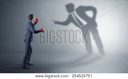 Businessman fighting with his bossy yelling shadow