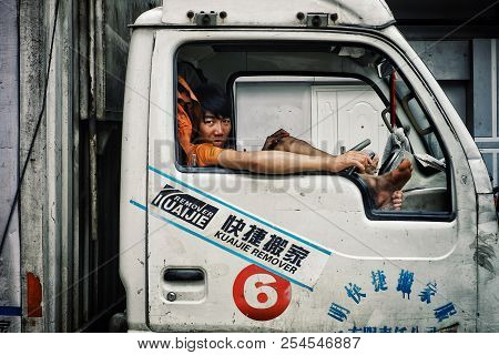 Beijing / China - Jun 24 2011: Young Boy Waiting In The Cabin Of A Lorry