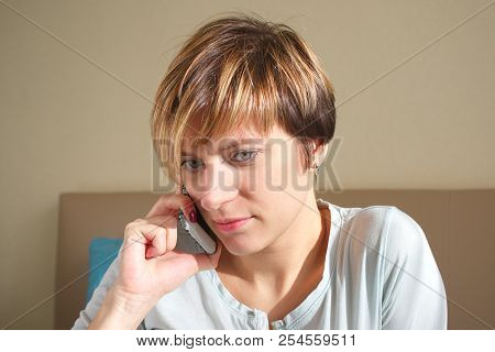 Seriosly Looking Young Womam Talking On Mobile, Indoor Portrait
