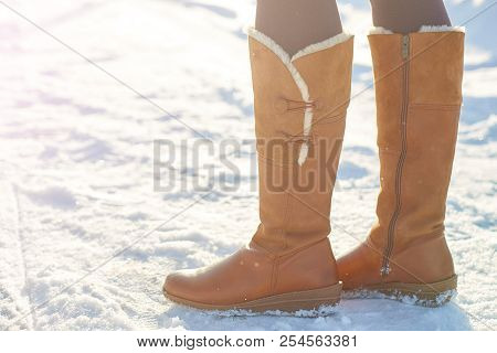 Leg Woman Winter Brown Fur Boots Walking On The Snow In A Winter Park. Closeup Outsole Of Warm Boot.
