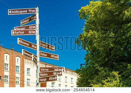 Street Sign With Directions Pointers And Distances To The Different Cities Of The World. Rostock, Ge