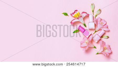 Flowers And Nail Poloshes Composition On Pink Table