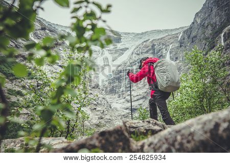 High Mountain Hiker With Poles. Alpine Trailhead. Recreation Theme.