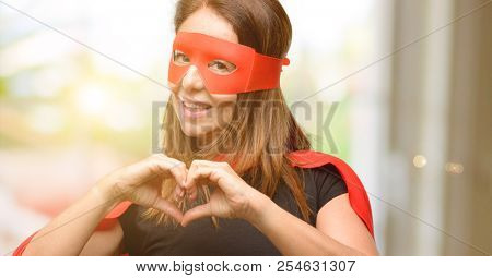 Middle age super hero woman wearing red mask and cape happy showing love with hands in heart shape expressing healthy and marriage symbol