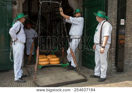 Alkmaar, Netherlands - July 20, 2018: Cheese carriers waiting for the cheeses to be weighted on the scale in the Waag building before being sold on the market