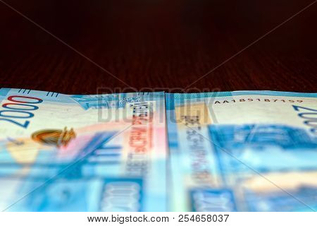 Russian Two Thousandth Notes Close-up Against The Background Of A Dark Wooden Table