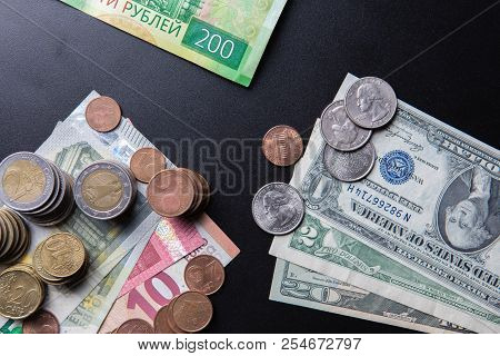 Euros And Usa Dollars Banknotes And Coins With Russian Two Hundred Rubles Banknote On Black Backgrou