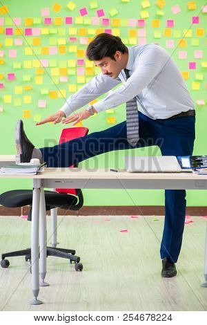 Man in the office with many conflicting priorities doing exercis