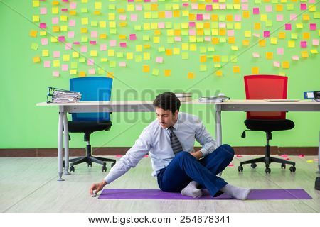Man in the office with many conflicting priorities doing exercis