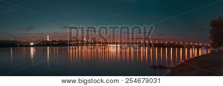 Panorama Of Kiev City At Night. Kyiv Left Bank Skyline With Paton Bridge Over Dnieper River.
