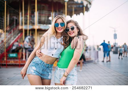 Happy Brightful Positive Moments Of Two Stylish Girls Hugging On Street In City. Closeup Portrait Fu