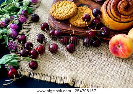 Homemade Cinnamon Buns In Glaze On A Dark Plate With Berries