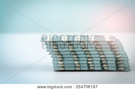 Stack Of Sugar Coated Tablet Pill  On White Background. Pharmacy Background. Health Budgets And Poli