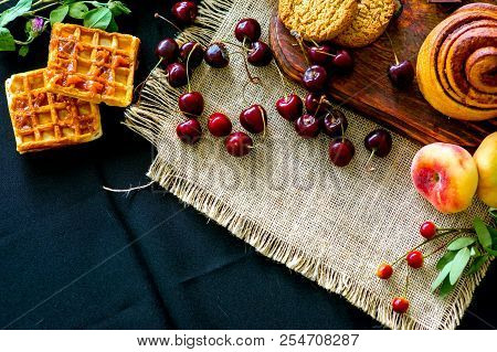 Homemade Cinnamon Buns In Glaze On A Dark Plate With Berries