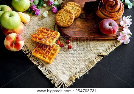 Homemade Cinnamon Buns In Glaze On A Dark Plate With Berries