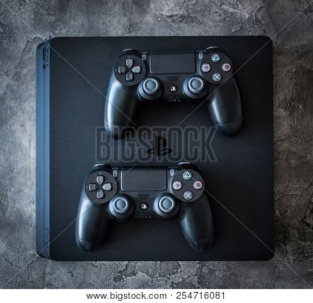 Khakiv, Ukraine - 02 May 2018: Top view of Sony Playstation 4 system with controllers on grey background. Home video game console