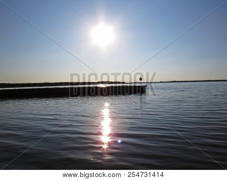 Wharf Catwalk During Sunset Over Beautiful Lake With Cloudy Sky In The Background