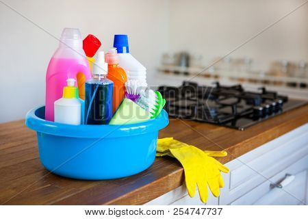 Basket With Cleaning Items On Blurry Background White Citchen. Cleaning Concept.