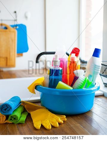 Basket With Cleaning Items On Blurry Background White Citchen. Cleaning Concept.