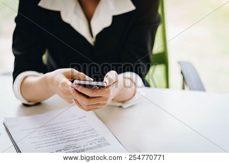 Businesswoman Working With A Mobile Phone Above The Contract And Calculator. Business And Partnershi