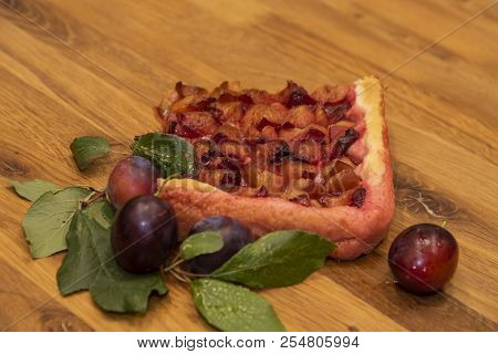 Piece Of Plum Cake And Fresh Plums On A Wooden Tray.