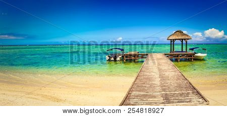 Sandy tropical Wolmar beach at sunny day. Jetty on the foreground. Beautiful landscape panorama. Mauritius