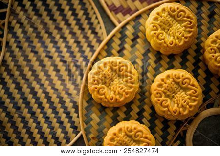 Traditional moon cakes is offered to friends or family during Mid-Autumn Festival. Flatlay on table, top down view low light with copy space. The Chinese character represent 